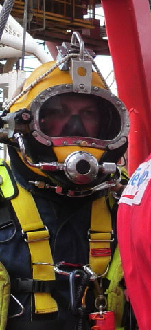 Close-up portrait of Stu Sutcliffe through a commercial diving helmet visor